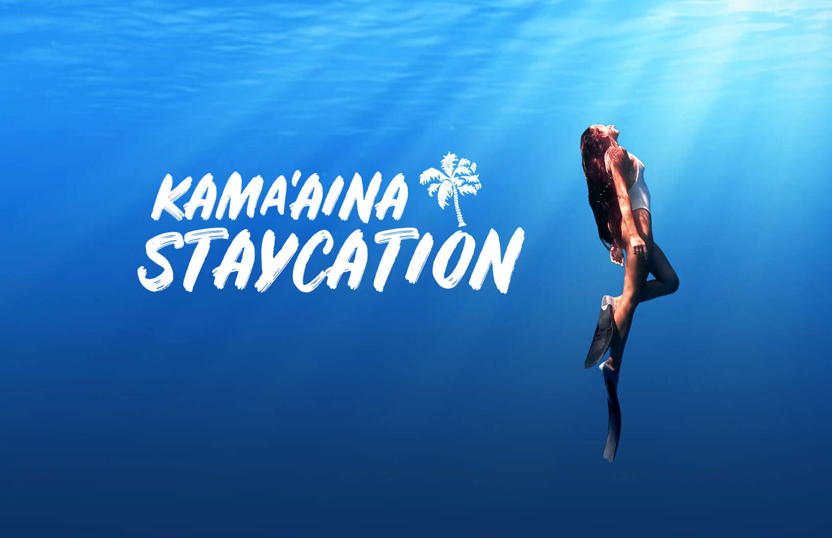 A woman with flippers swimming in the ocean with the words "Kama'aina Staycation" next to her